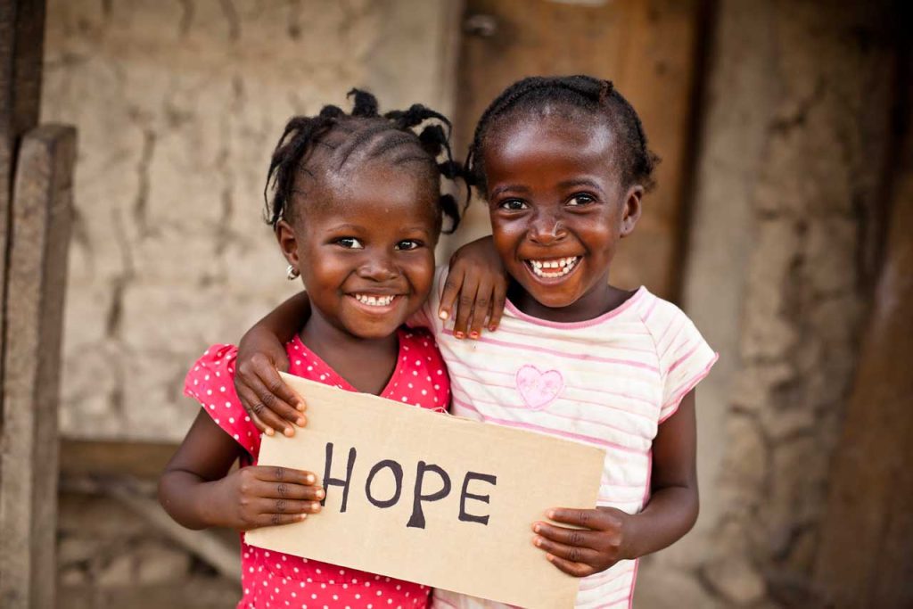 Two children smile with a "hop" inscription as they join in the Celebrate Xmas with vulnerable children in cape coast'' program